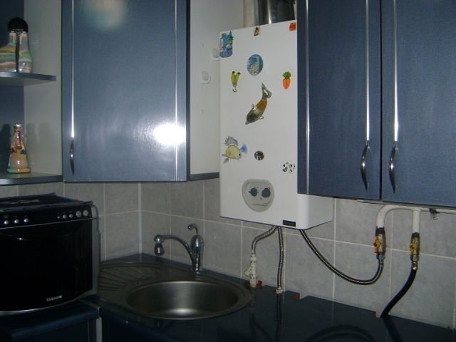 Газовая колонка над мойкой на кухне
