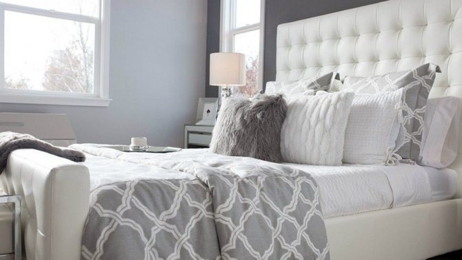 Спальня с кроватью с мягким изголовьем серого цвета